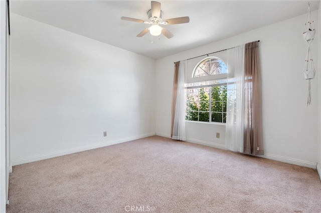 spare room featuring light carpet and ceiling fan