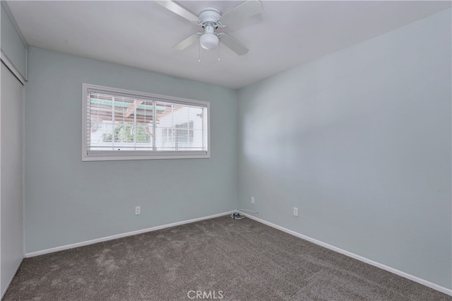 unfurnished bedroom featuring ceiling fan and dark colored carpet