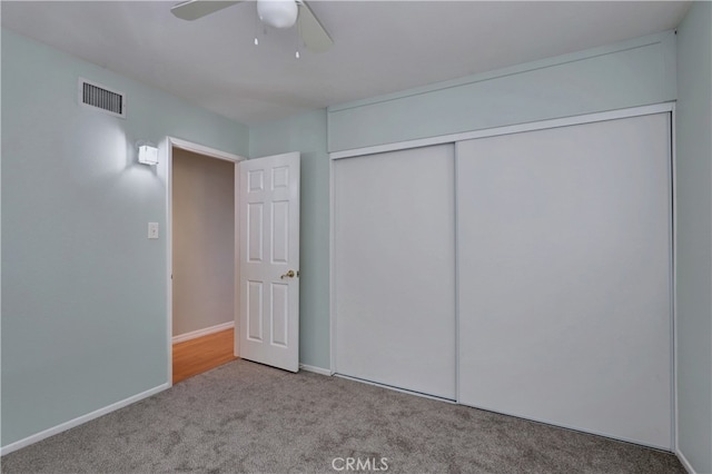 unfurnished bedroom with ceiling fan, a closet, and light colored carpet