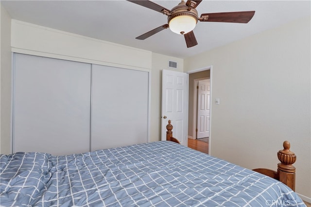 bedroom with a closet, hardwood / wood-style floors, and ceiling fan