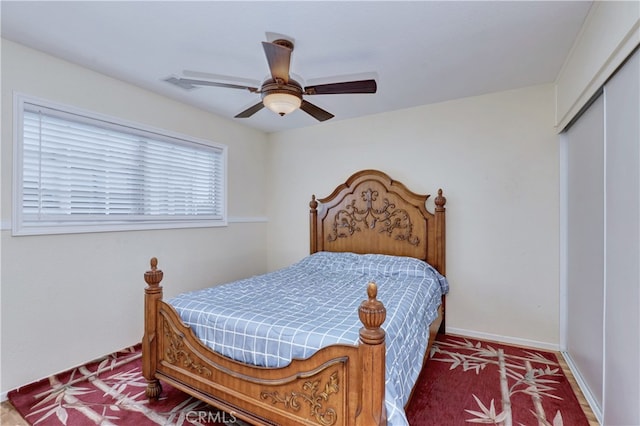 bedroom featuring ceiling fan, a closet, and dark colored carpet