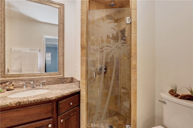 bathroom featuring a shower with shower door, vanity, and toilet