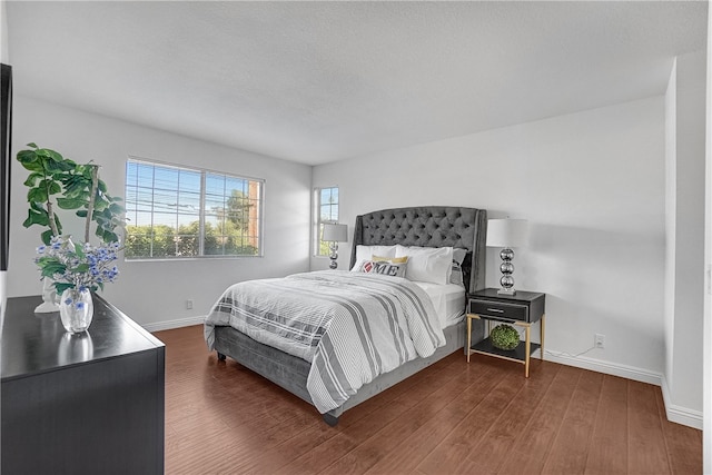 bedroom with a textured ceiling and dark hardwood / wood-style floors