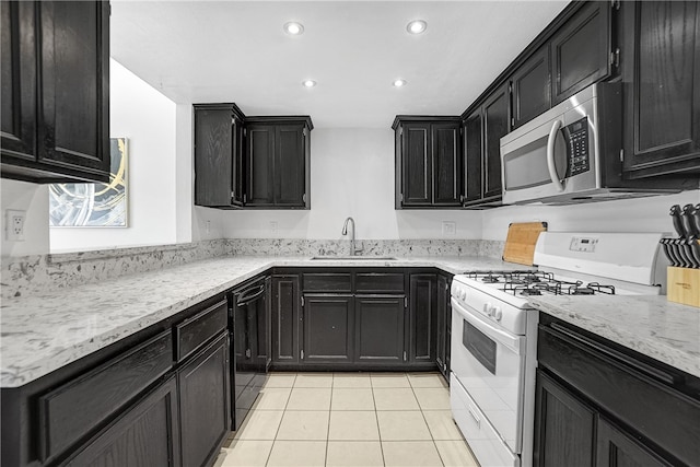 kitchen with white range, light tile patterned flooring, and sink