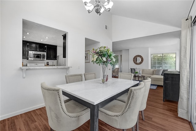 dining room featuring a notable chandelier, dark hardwood / wood-style floors, and high vaulted ceiling