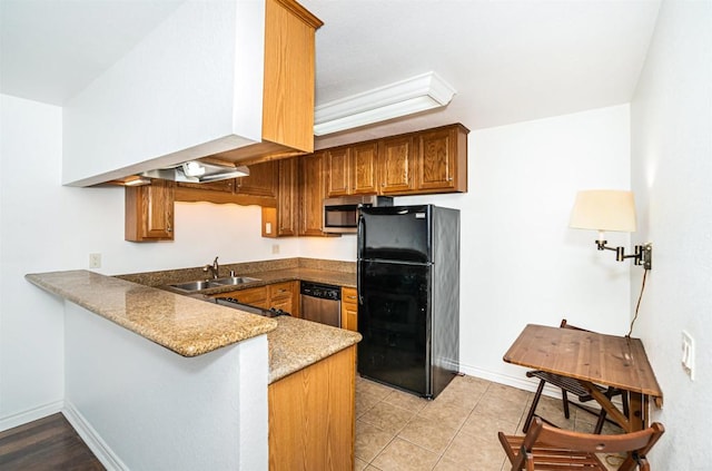 kitchen with stone counters, sink, light tile patterned flooring, kitchen peninsula, and stainless steel appliances