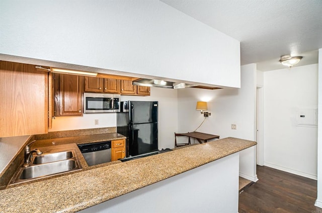 kitchen featuring appliances with stainless steel finishes, sink, dark hardwood / wood-style floors, and kitchen peninsula