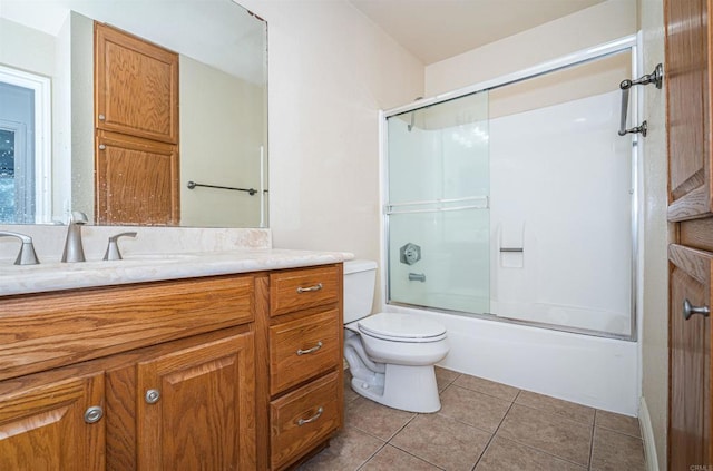 bathroom featuring tile patterned floors, bath / shower combo with glass door, toilet, and vanity