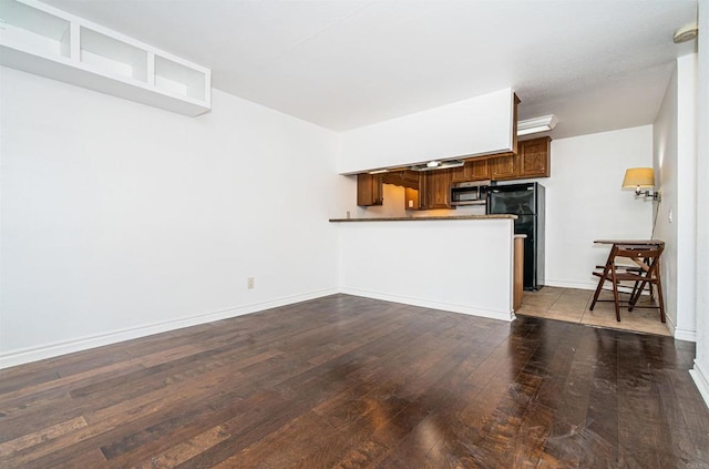 unfurnished living room with baseboards and hardwood / wood-style floors