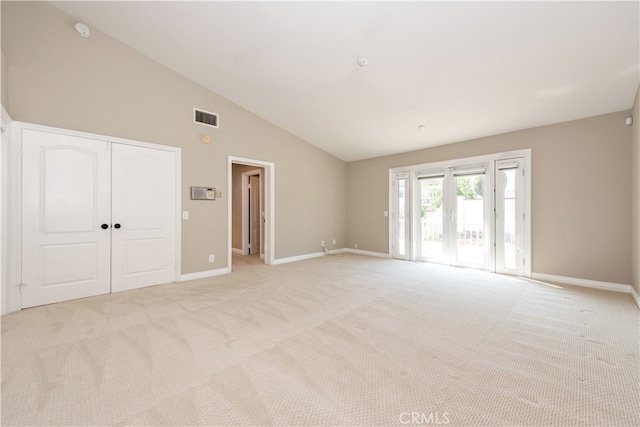 carpeted spare room with lofted ceiling