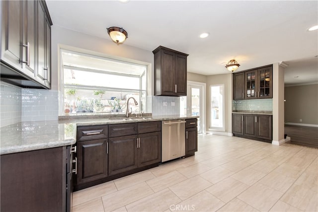 kitchen featuring dark brown cabinetry, dishwasher, sink, and tasteful backsplash