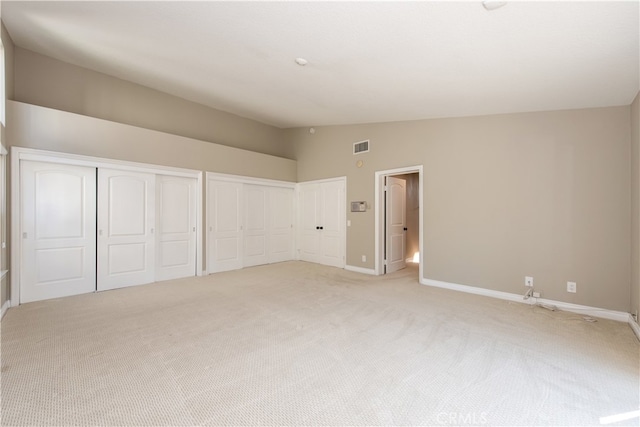 unfurnished bedroom with lofted ceiling and light colored carpet