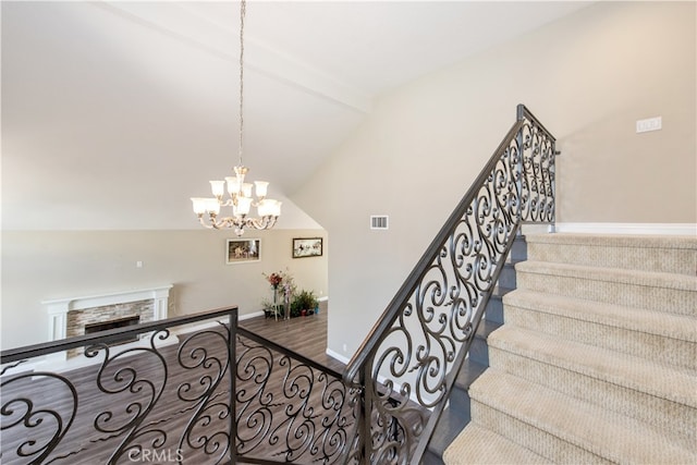 staircase with hardwood / wood-style flooring, lofted ceiling, and a notable chandelier