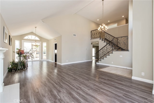 unfurnished living room with an inviting chandelier, high vaulted ceiling, and dark wood-type flooring