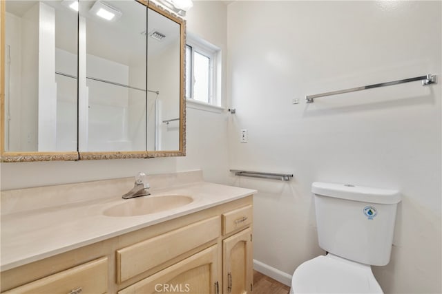 bathroom featuring wood-type flooring, vanity, and toilet