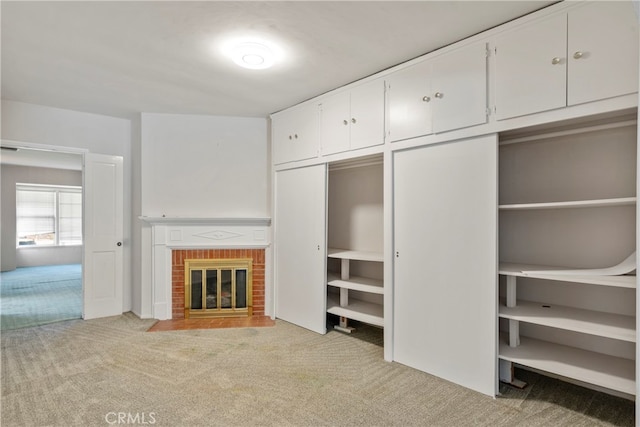 unfurnished living room with a fireplace and light colored carpet