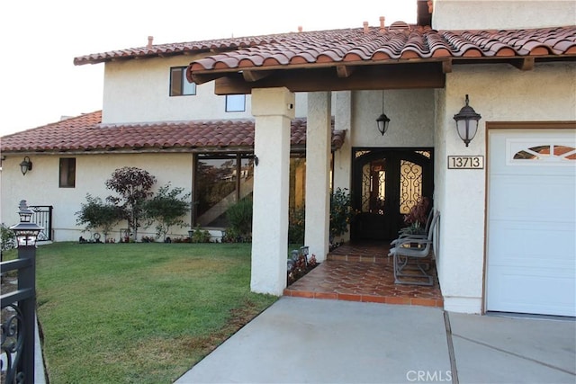 view of exterior entry featuring a yard and a garage