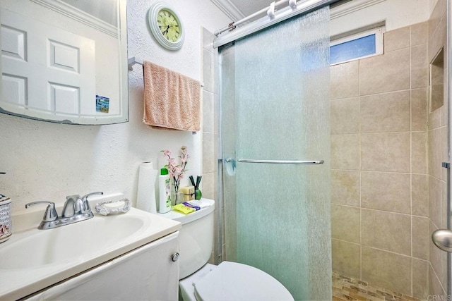 bathroom with ornamental molding, vanity, toilet, and a shower with door