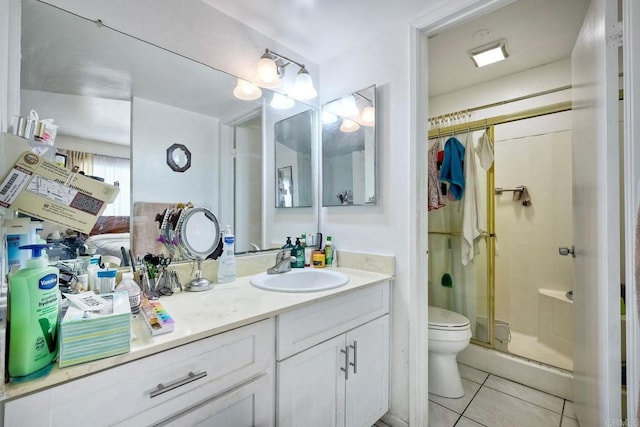 bathroom with vanity, toilet, tile patterned floors, and a shower with shower door