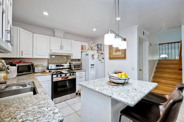 kitchen with pendant lighting, white cabinetry, a kitchen island, appliances with stainless steel finishes, and light tile patterned floors