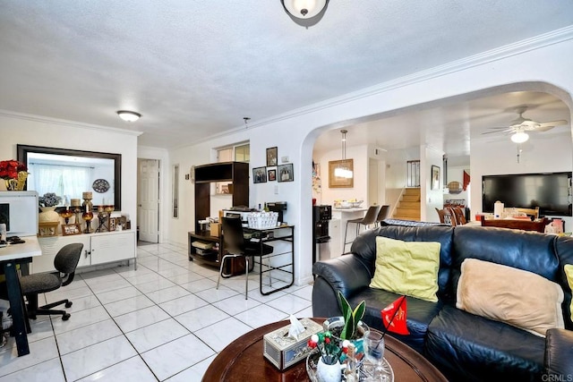 living room featuring ceiling fan, light tile patterned flooring, and crown molding