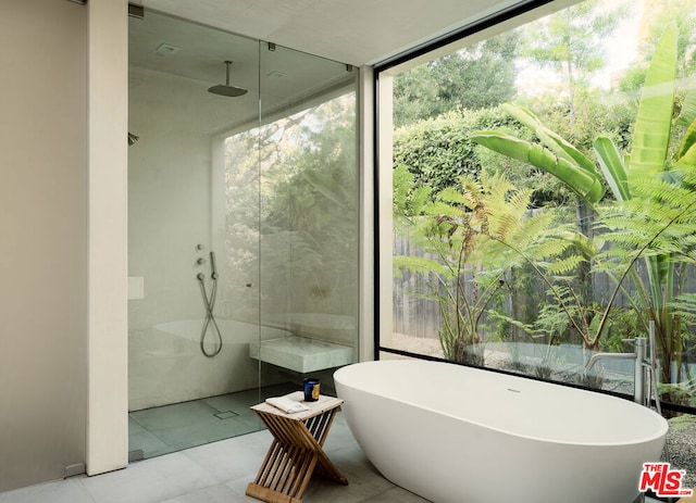 bathroom with separate shower and tub and tile patterned flooring