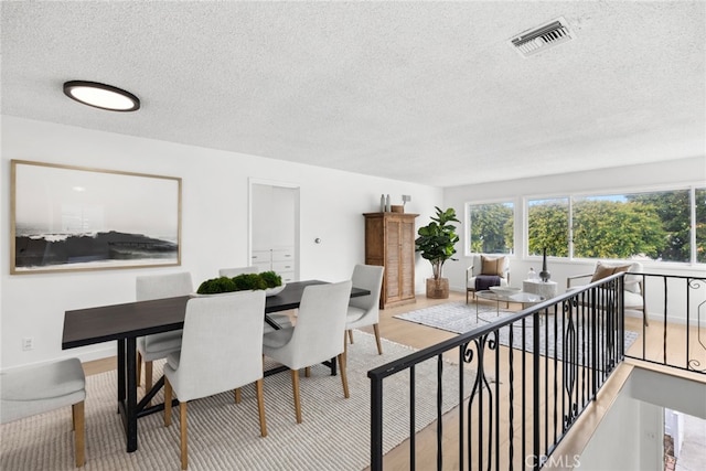 dining room featuring light hardwood / wood-style floors and a textured ceiling