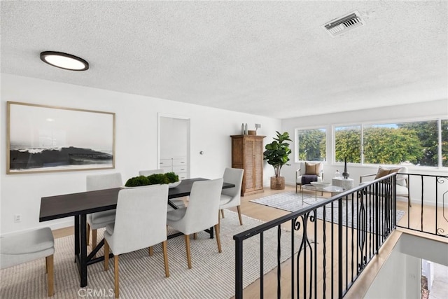 dining area featuring a textured ceiling and visible vents