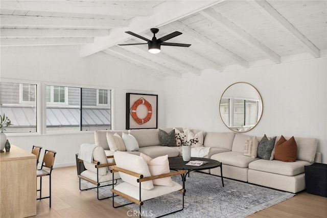 living area with light wood-style flooring, vaulted ceiling with beams, and a ceiling fan