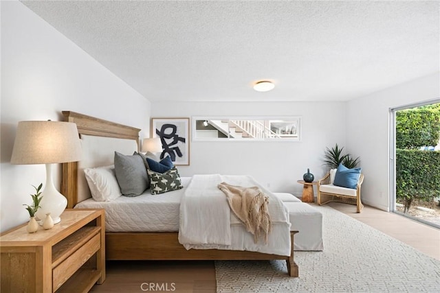 bedroom featuring wood finished floors and a textured ceiling