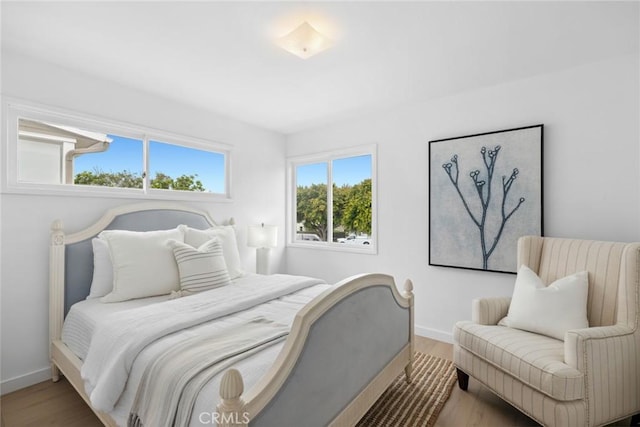 bedroom with baseboards and wood finished floors
