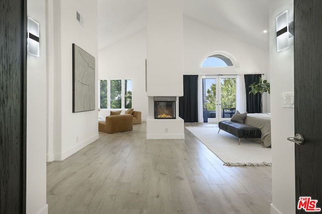 interior space featuring french doors, light hardwood / wood-style flooring, and high vaulted ceiling