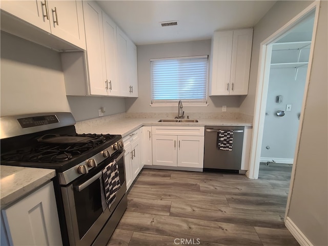 kitchen featuring light hardwood / wood-style flooring, stainless steel appliances, white cabinets, and sink