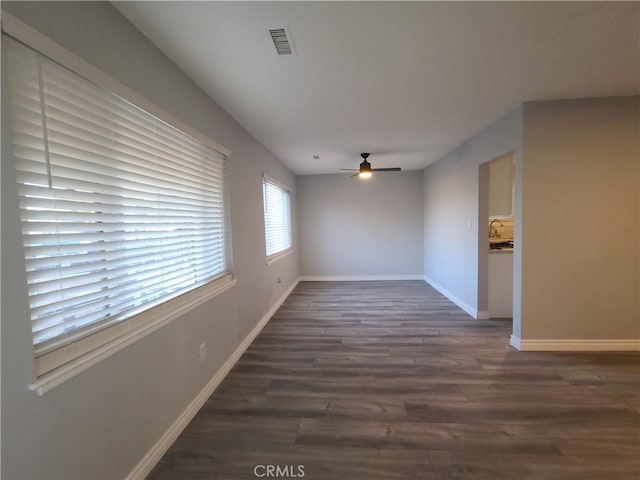 empty room with ceiling fan and dark wood-type flooring