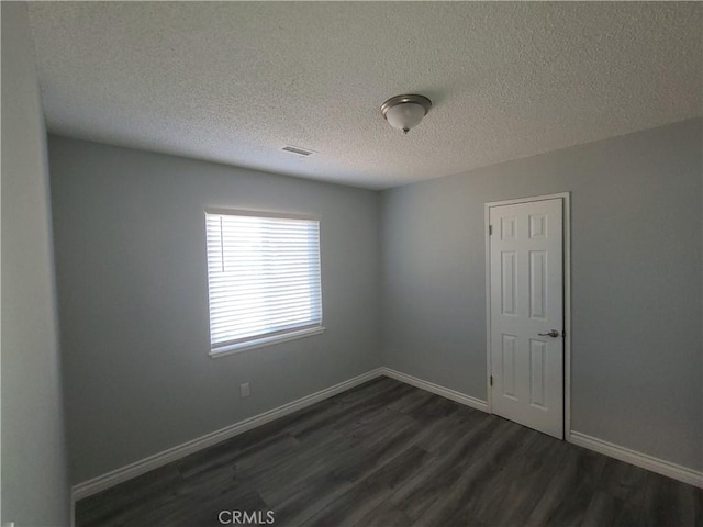 38633 Glenbush Ave, Palmdale, CA 93550 - unfurnished room with dark wood-style floors, a textured ceiling, and baseboards
