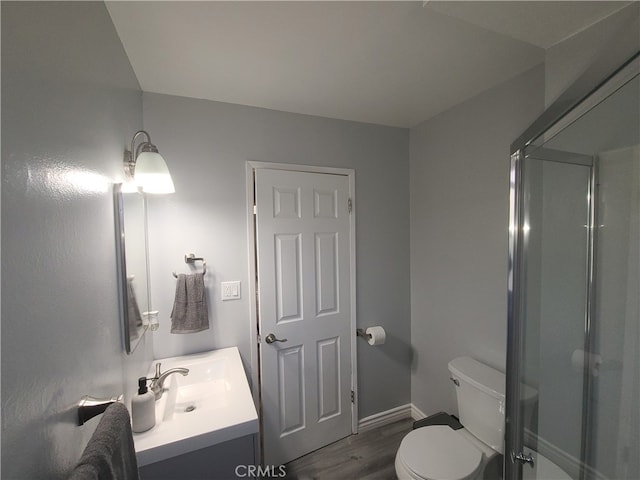 bathroom with walk in shower, vanity, toilet, and wood-type flooring