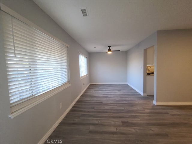 unfurnished room featuring ceiling fan and dark wood-type flooring