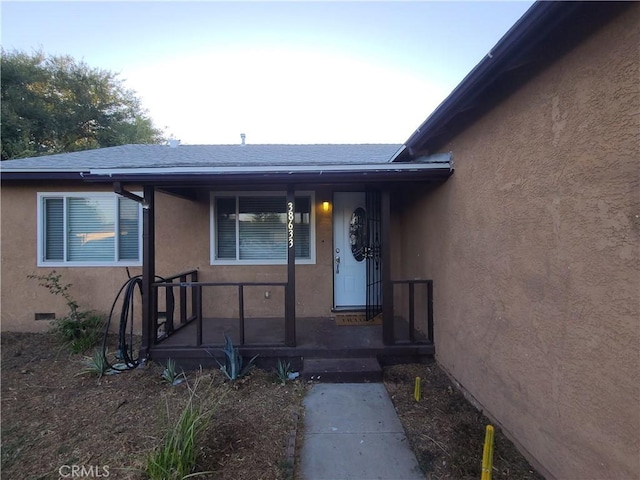 38633 Glenbush Ave, Palmdale, CA 93550 - view of exterior entry featuring stucco siding, crawl space, and a porch