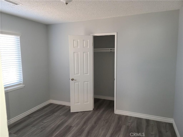 38633 Glenbush Ave, Palmdale, CA 93550 - unfurnished bedroom with dark wood-style floors, a closet, baseboards, and a textured ceiling