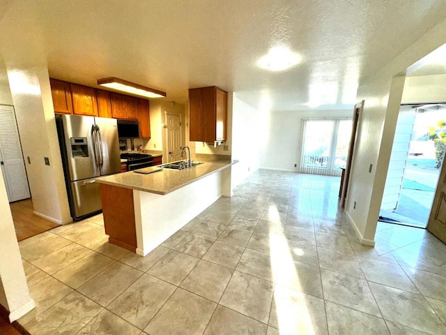 kitchen with black appliances, sink, light stone counters, kitchen peninsula, and a textured ceiling