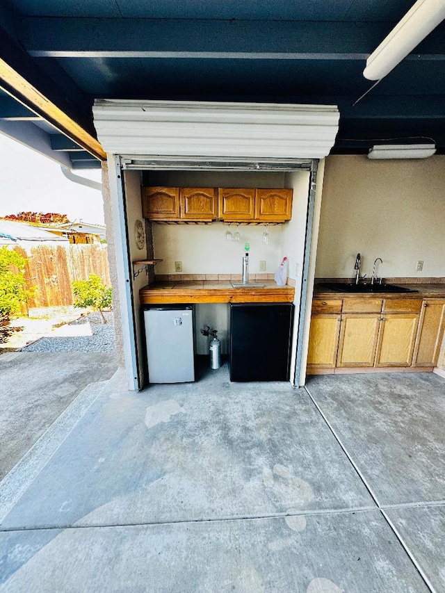 garage featuring stainless steel refrigerator and sink