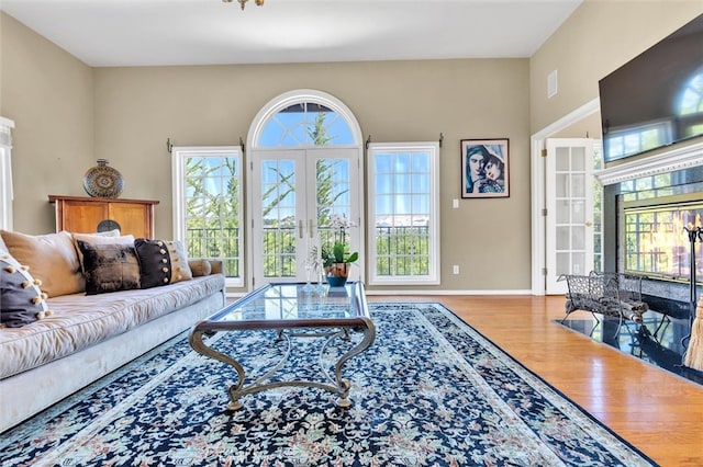 living room with a healthy amount of sunlight, french doors, and light hardwood / wood-style flooring