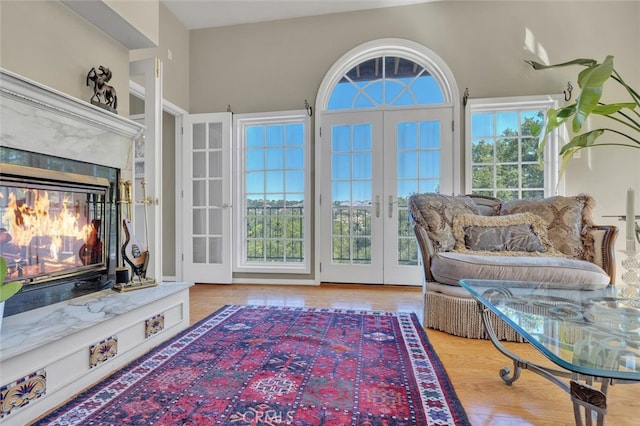 living area featuring french doors, a fireplace, and hardwood / wood-style floors