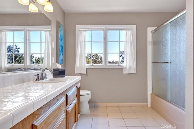 full bathroom featuring shower / bath combination with glass door, toilet, tile patterned flooring, and vanity