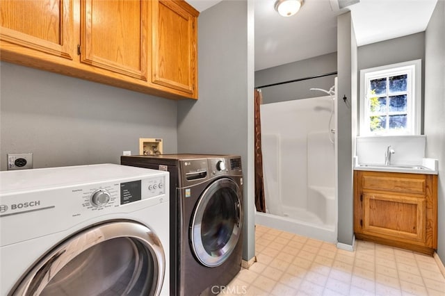 laundry area featuring washer and dryer, cabinets, and sink