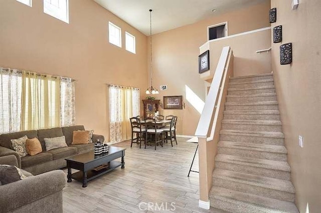 living room featuring a high ceiling, hardwood / wood-style floors, and a chandelier