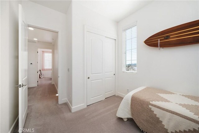 bedroom featuring light colored carpet and a closet