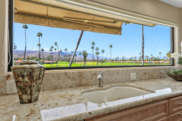 room details featuring a mountain view, light stone countertops, and sink