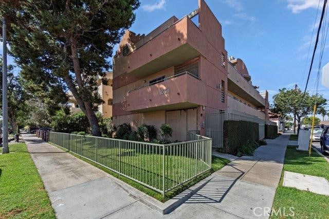 view of home's exterior featuring stucco siding, fence, and a yard