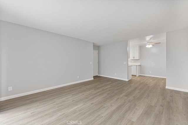 unfurnished living room featuring light hardwood / wood-style flooring and ceiling fan